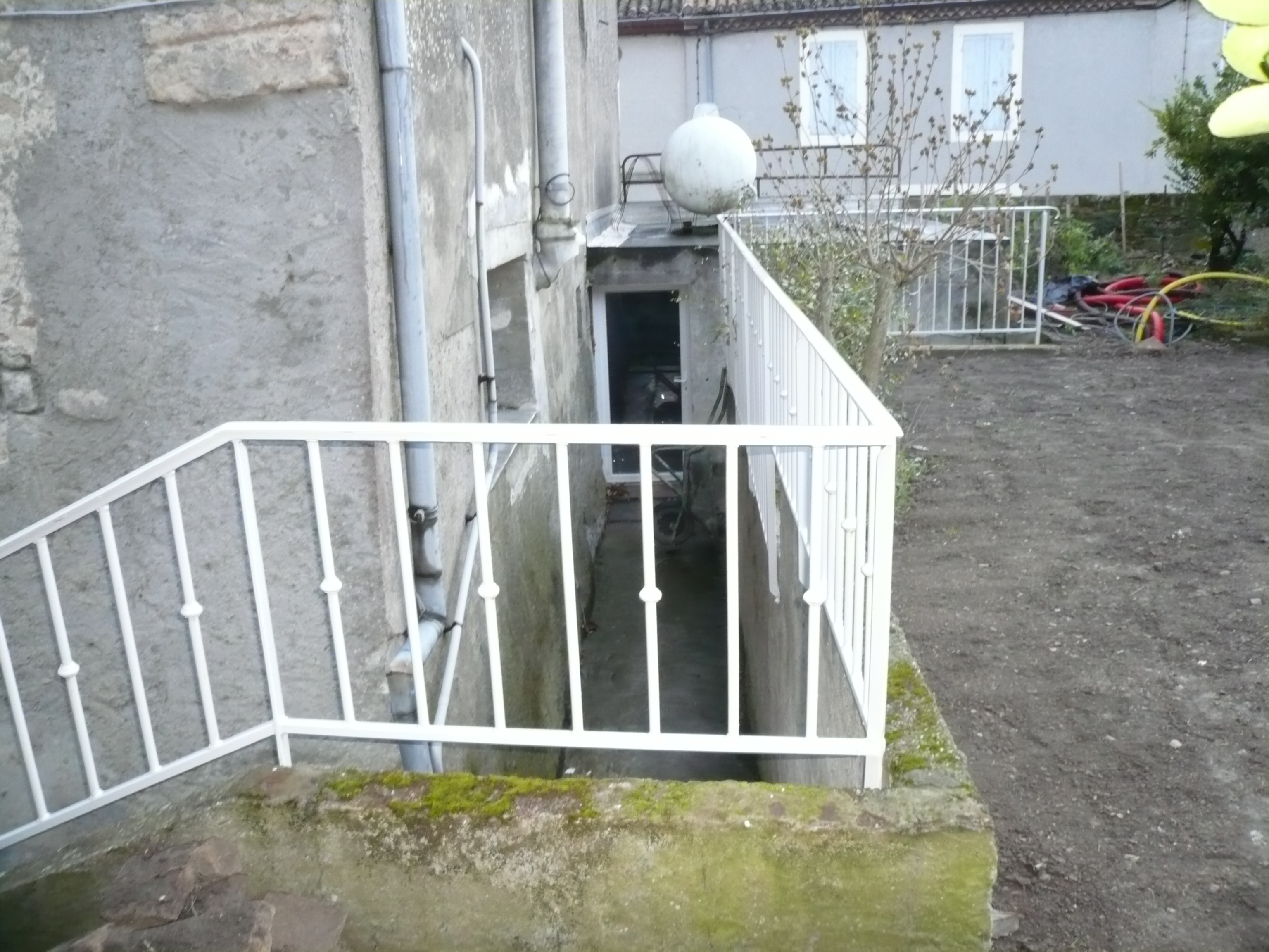 Entrée d'un bâtiment avec rampe blanche, vue extérieure, escalier et rampe