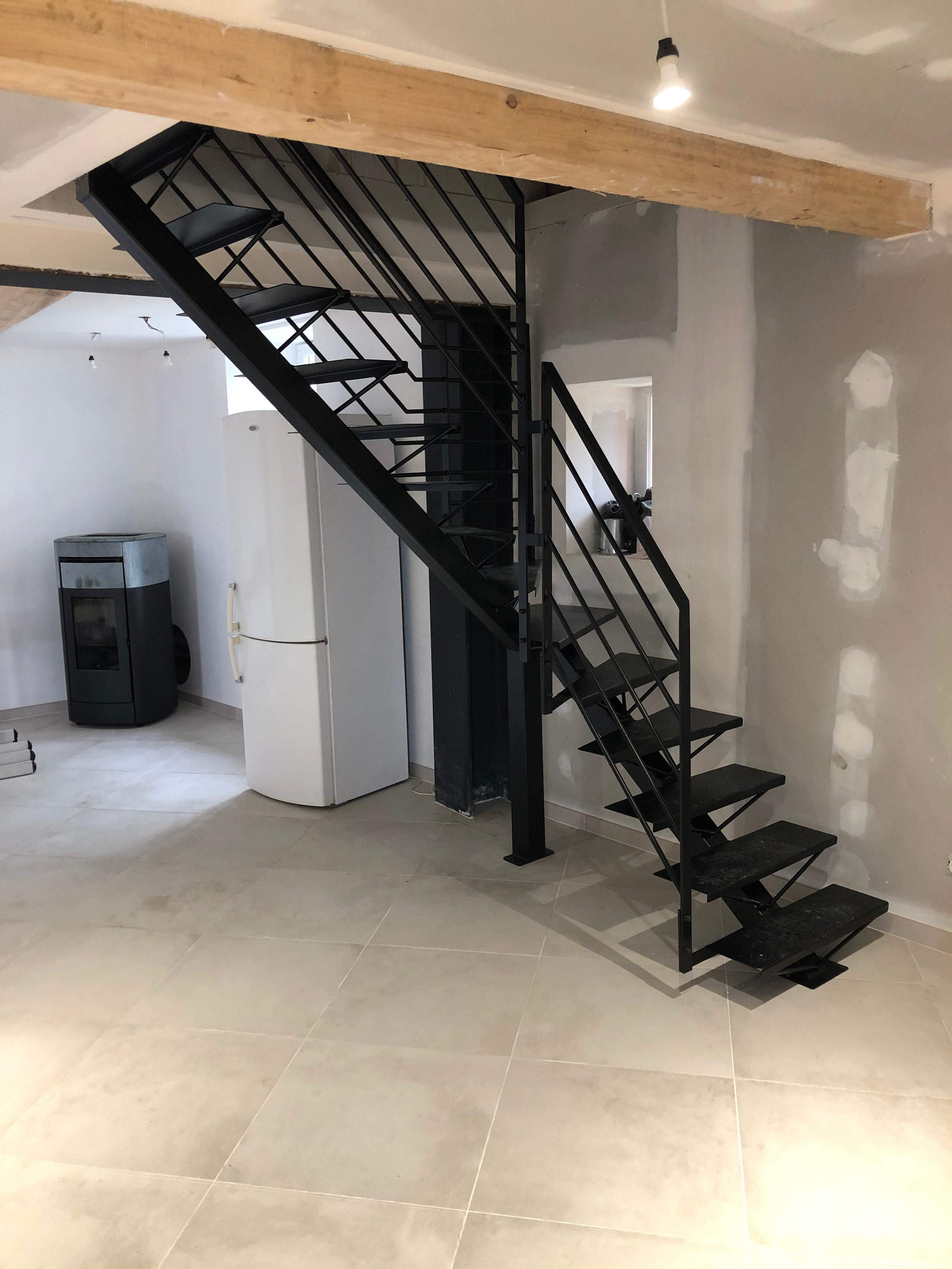 Escalier en métal noir et plafond en bois.