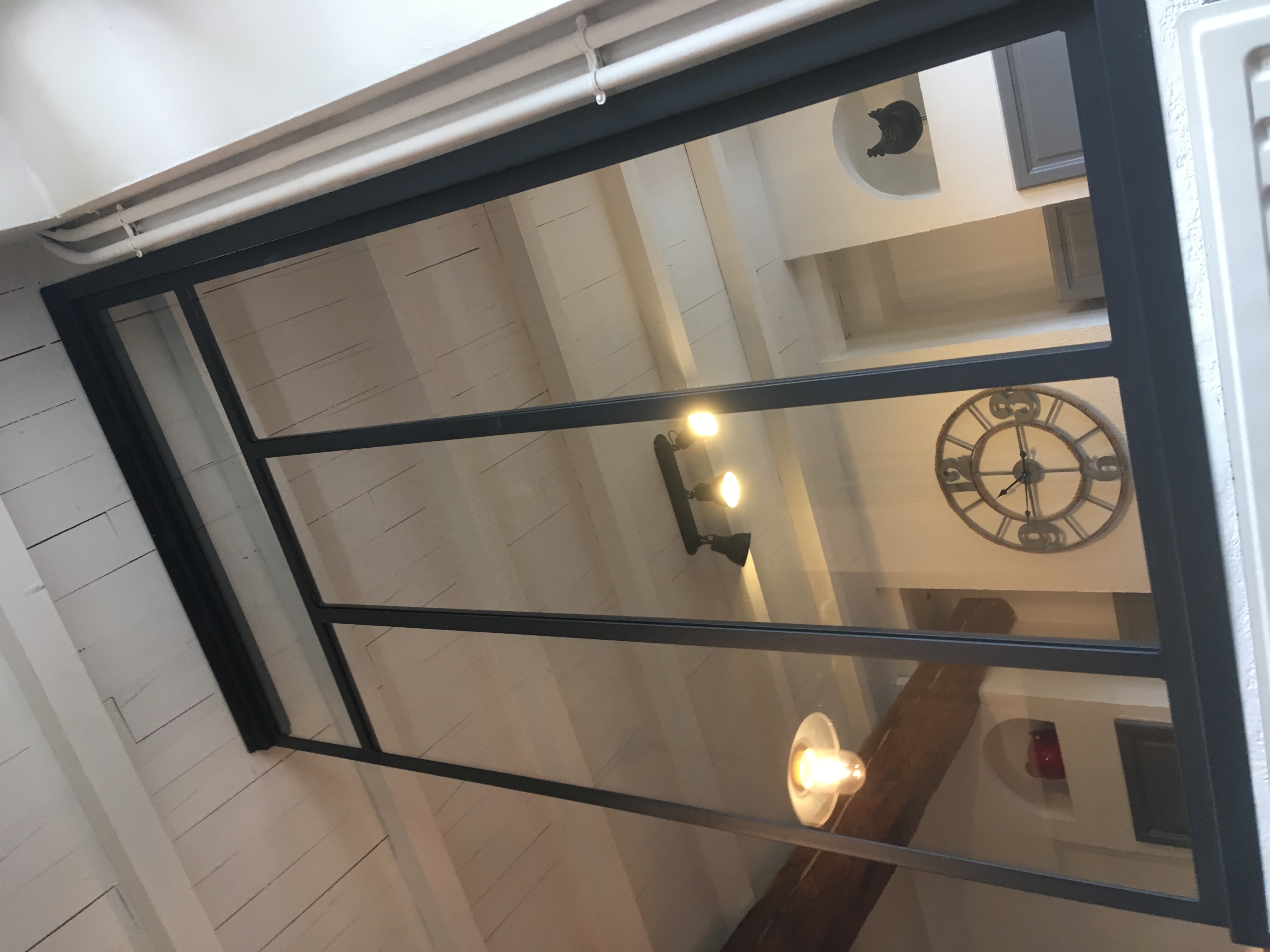 Une grande fenêtre, plusieurs carreaux, un intérieur. Verrière, horloge ancienne, éclairage, plafond.