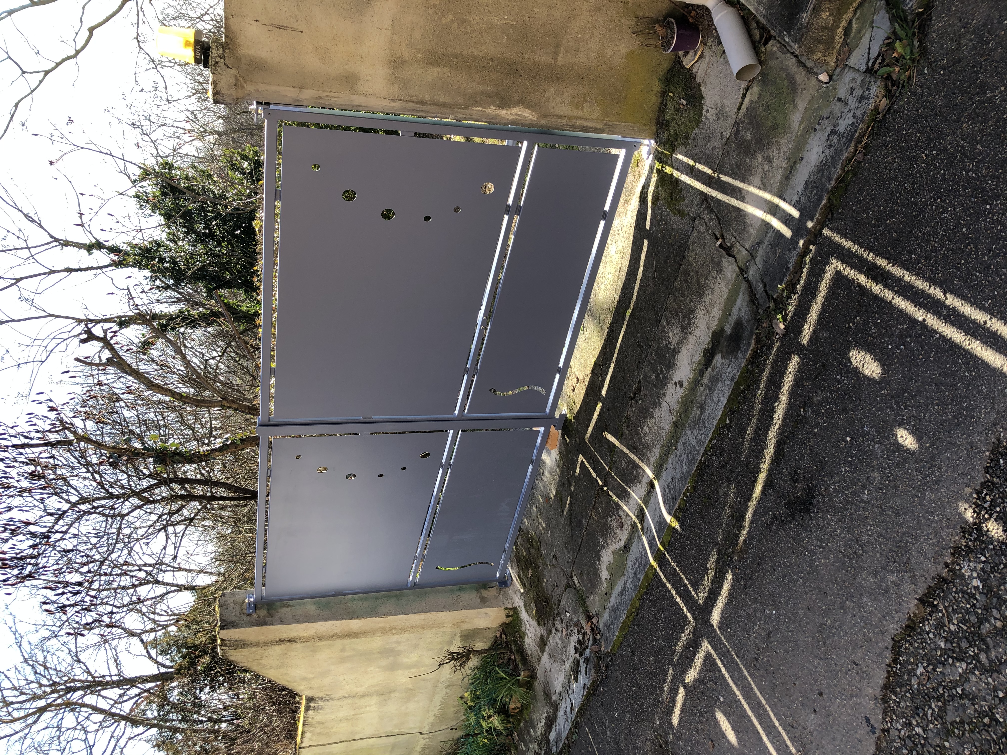 Grandes portes grises Portail entre deux murs en béton, détails de l'extérieur.