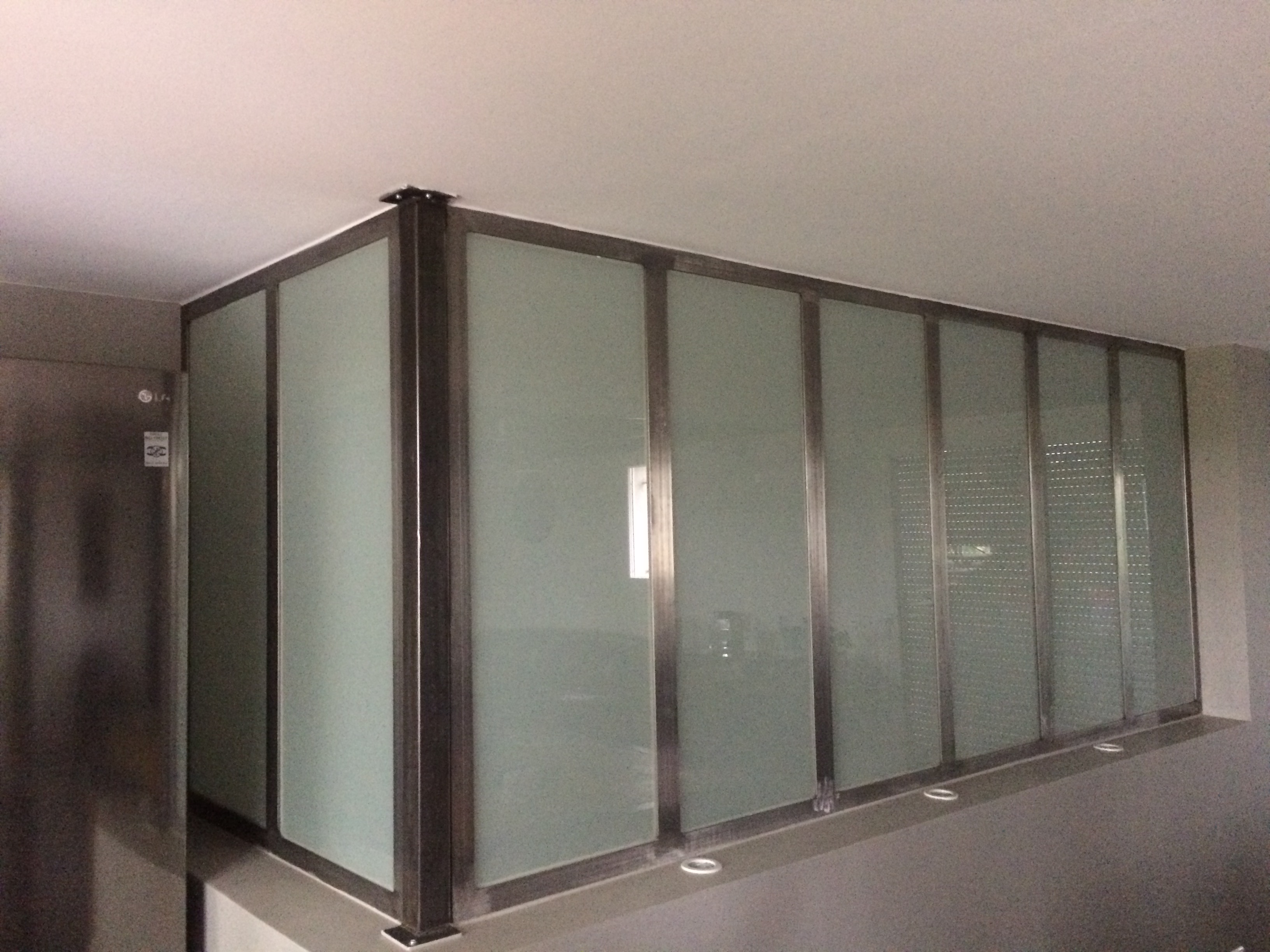 Structure vitrée avec plusieurs panneaux, installation moderne dans un intérieur.