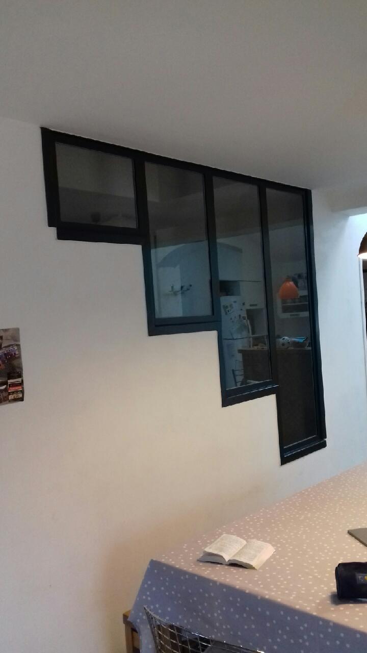 Verrière noire dans une pièce blanche, un livre ouvert sur la table, Christo.