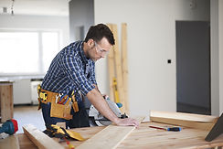 A man cutting a wooden plate with a saw