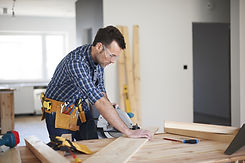 A man cutting a wooden plate with a saw