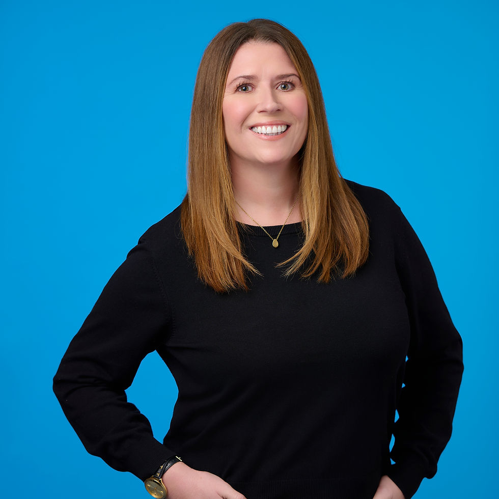 Headshot of Emma Witkowski wearing a black long sleeve shirt with a blue background