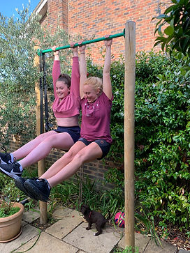 Girl doing fitness, leg raises and smiling outside. Personal trainer working with a teenage girl, ab exercises.