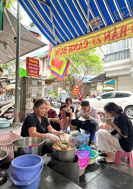 Local vendor preparing authentic Northern Vietnamese street food in Hanoi’s Old Quarter during a small group food tour.