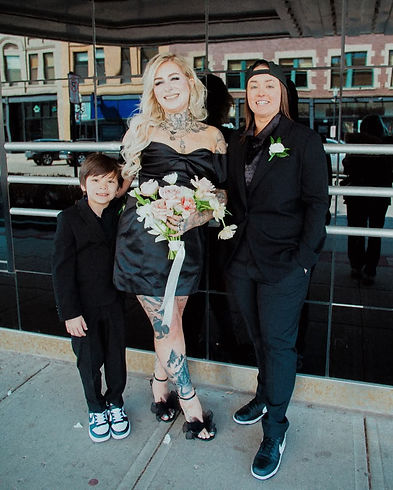 Hannah and family posing outside black building