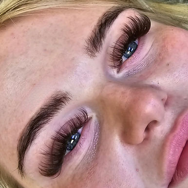 Custom wispy, brown volume lash extensions on blue eyes