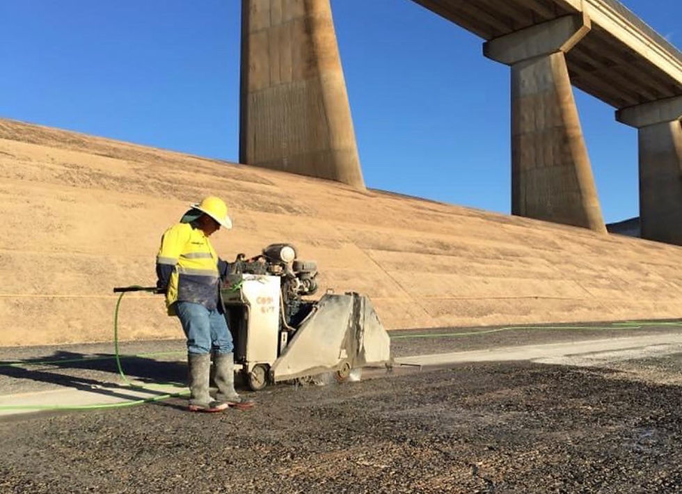 Cutting Force technician using a road saw at a bridge project, demonstrating precise concrete cutting services.