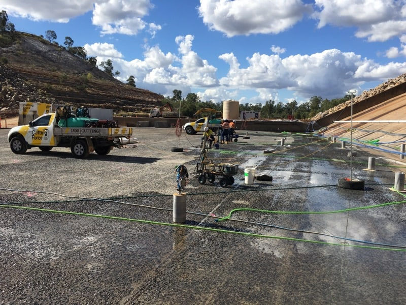 Cutting Force team performing concrete cutting at a dam site with specialised equipment and vehicles