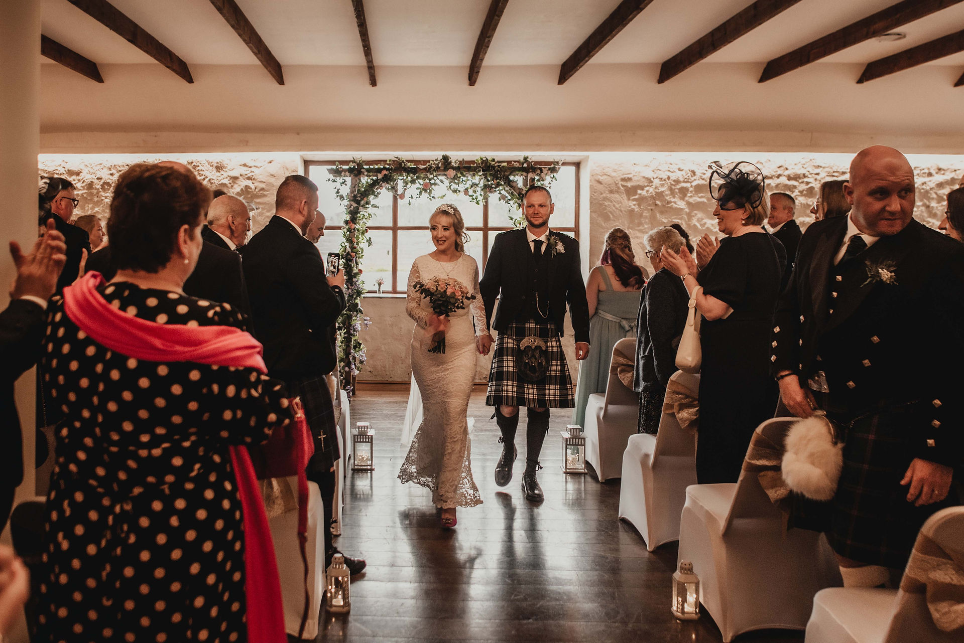 the bride and groom walk down the aisle after getting married at Bachilton Barn