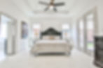 Sunlit residential bedroom with queen bed