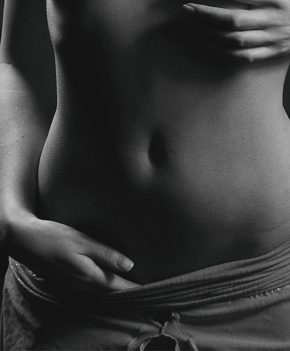 Foto em preto e branco com uma barriga feminina exposta