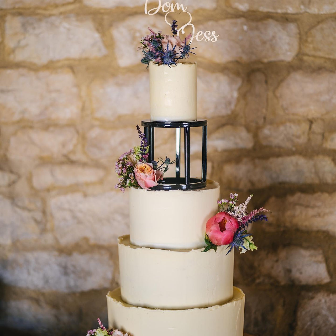 Plain buttercream wedding cake with bright colour flowers