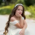 בתמונה נראית נערה החוגגת בת מצווה כשהיא יושבת ומביטה לעדשה. מבטה ישיר ובטוח, והיא משדרת שילוב של רוך ועמידות. התאורה מדגישה את פניה ומוסיפה לאווירה חגיגית ואישית של הצילום
