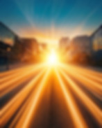 A bright sunset illuminating a city street.