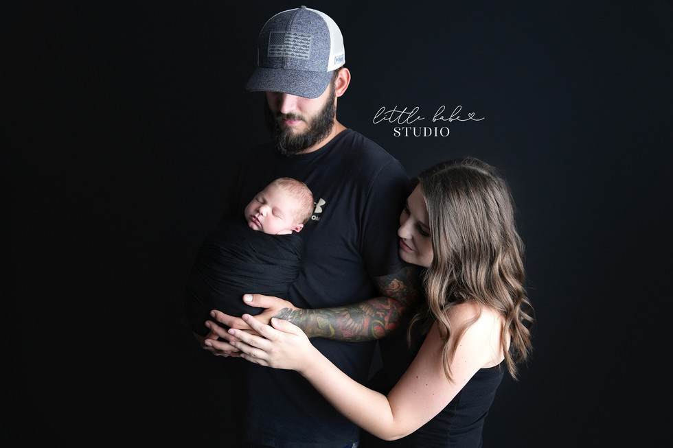 Middletown Ohio Newborn Photography Studio family photo session on black backdrop with baby boy wrapped in black fabric wrap