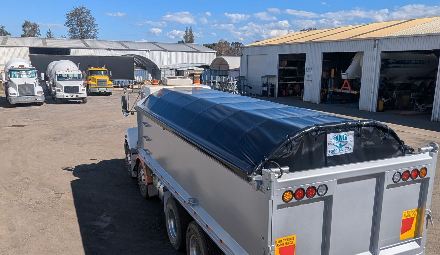 Kenworth truck parked in Powertarps Penrth fitment workshop with other trucks