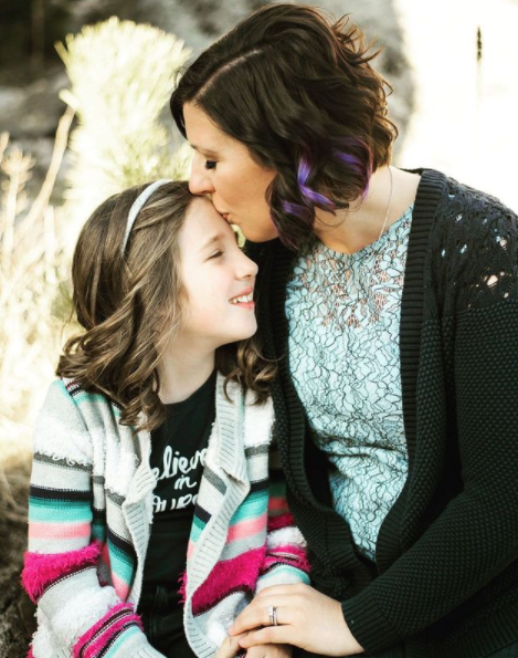 mama kissing daughter on the forehead