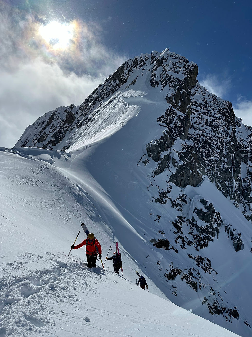 Skiers bootpacking up a couloir