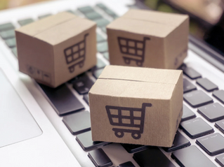 boxes with shopping cart icon on top of a laptop