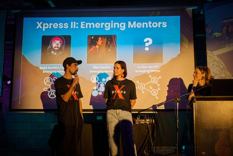 Two people speaking on stage with a presentation.