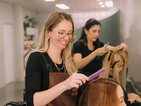 Stylist applying a keratin treatment to a client's hair in the salon