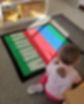 Child lays out cards that show the numbers 1000 to 9000.