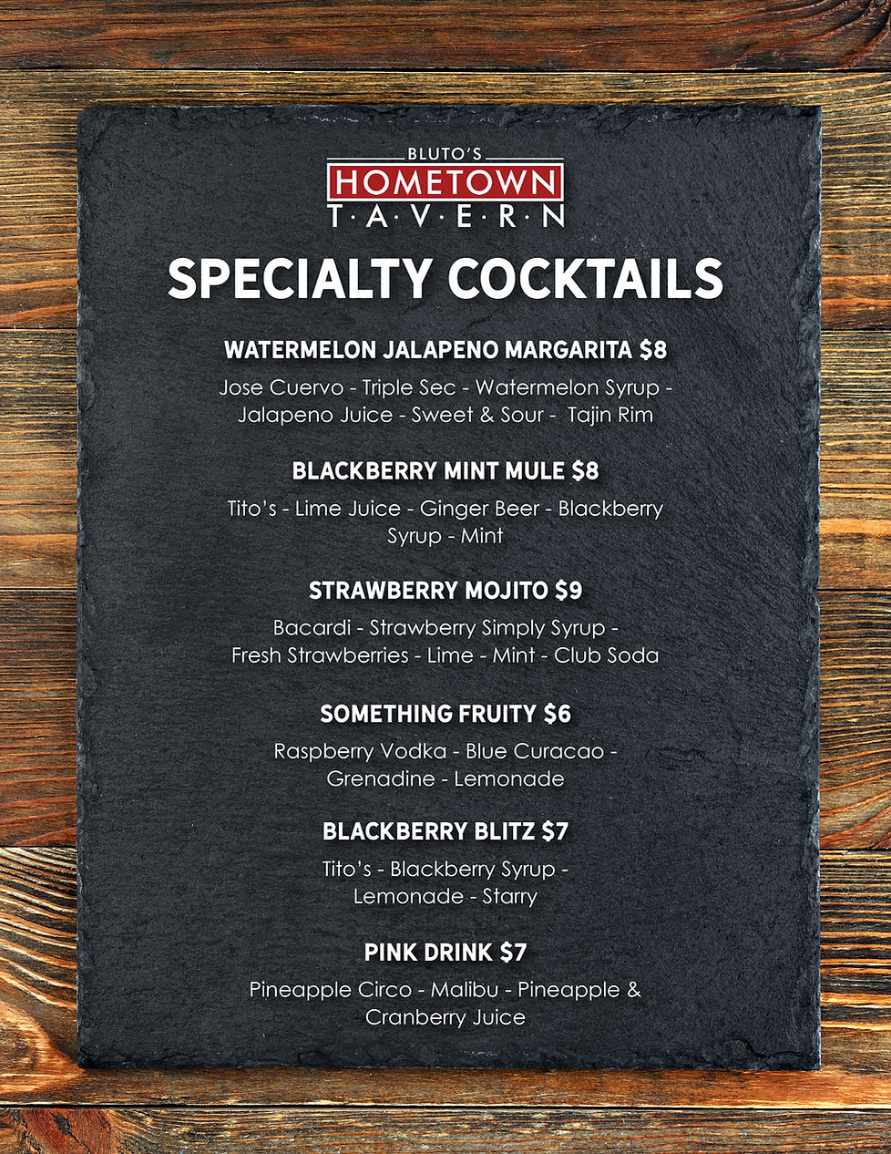 Bluto's Hometown Tavern's specialty cocktails listed on a black chalkboard with a wooden border.