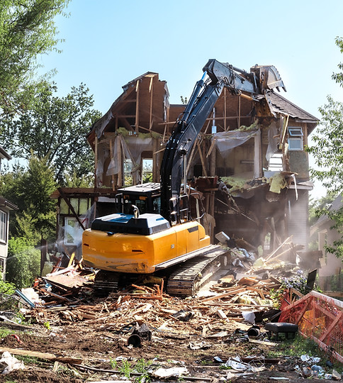 An excavator tearing down a house.