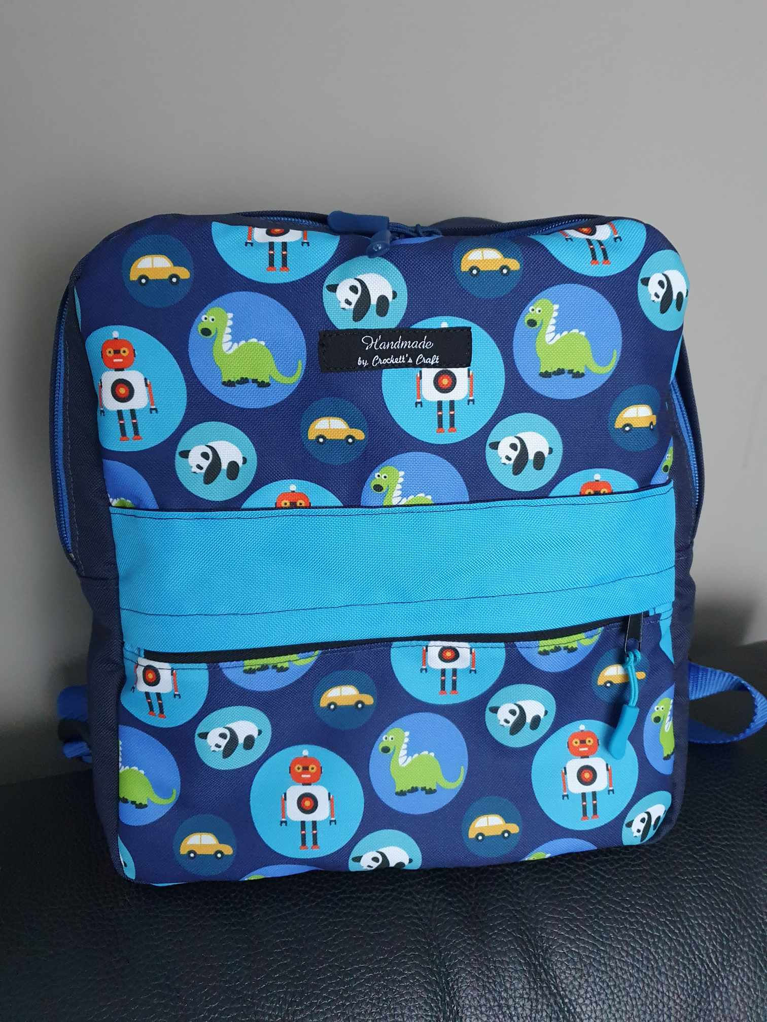 Frontansicht Rucksack mit Roboter, Pandas und Dinos