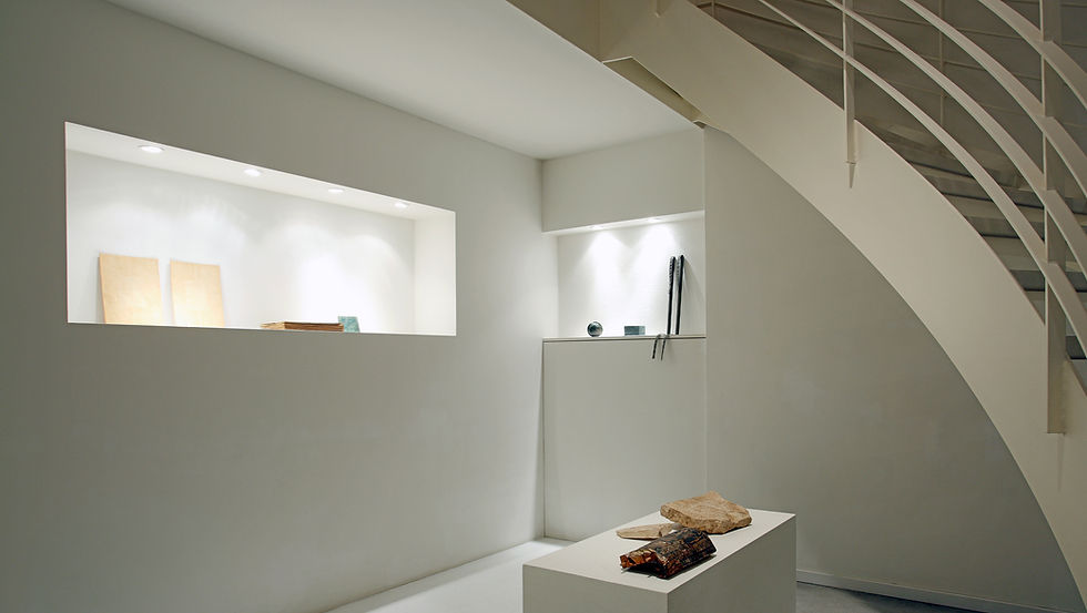 Galerie Cahn ground floor: archaeological objects and contemporary art beneath the spiral staircase, Basel.