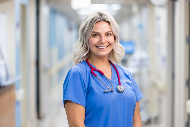 Smiling nurse portrait in hospital hallway, professional healthcare photography in Pittsburgh
