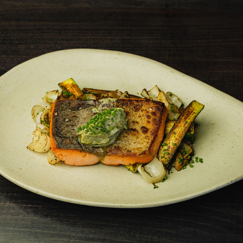 Grilled salmon fillet with a crispy golden crust, served with citrus-infused olive oil and charred seasonal vegetables.