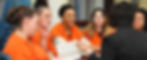 Women in orange jumpsuits meeting with a U.S. Ministry representative