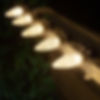 Close-up of warm white C9 Christmas bulb installed outdoors