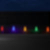 Red, blue, yellow, and green C9 Christmas bulbs illuminated at night