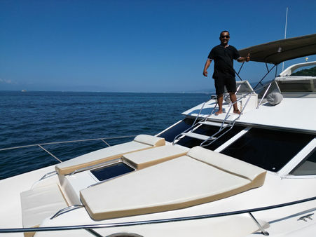 A man dressed inblack standing on the sundeck of a yacht