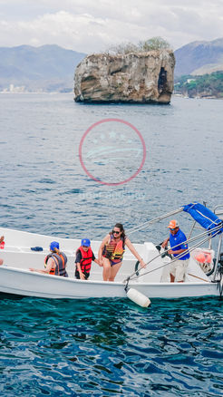 People on a tende rin front of Los Arcos Mismaloya
