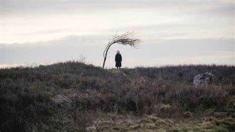 The woman from 73 yards, in the distance, grassy clifftop