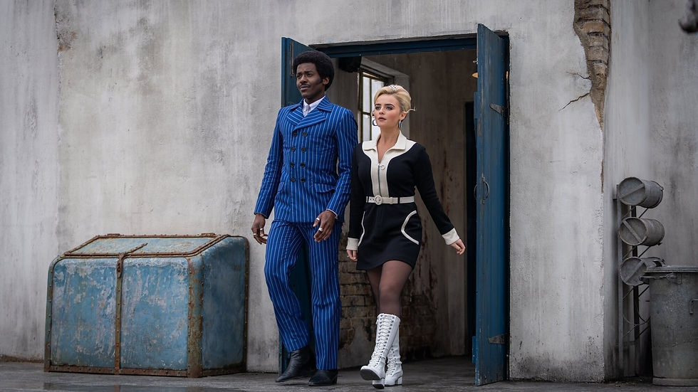Fifteen in blue and white pinstripe suit, Ruby in black and white dress and white boots, walking side by side onto a rooftop
