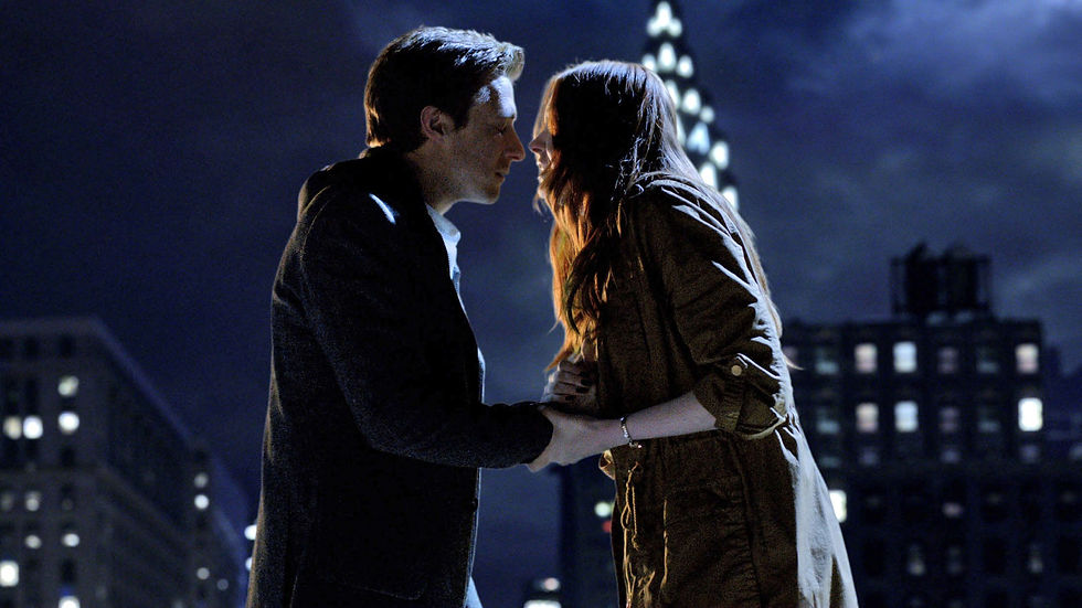 Amy and Rory holding each other on top of a New York building at night