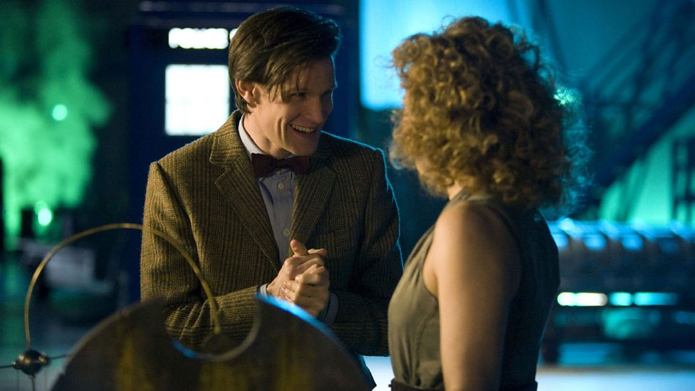 The Doctor giggling looking at River, a cot is below them