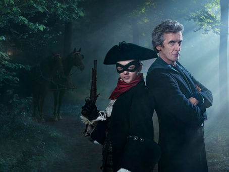 Ahildr with mask and gun posing back to back with the Doctor who has his arms crossed. A horse is behind them and they are in a wooded area