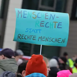 Schild mit der Aufschrift Menschenrechte statt rechte Menschen