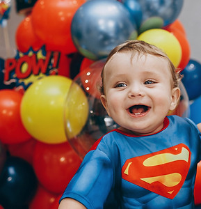 a baby in a superman costume sitting in front of balloons_edited.jpg