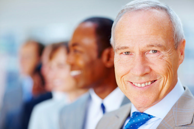 happy-senior-executive-with-colleagues-in-backgrou-2025-04-06-10-39-56-utc-SMALL.jpg