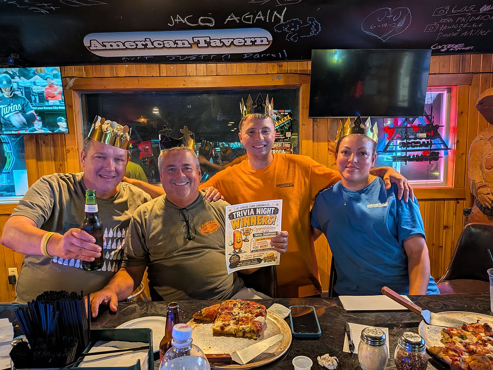 Group of four trivia winners at a bar wearing crowns