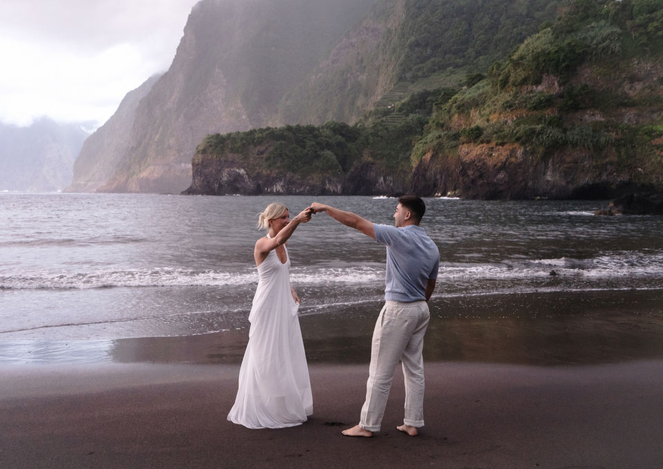 Couple dancing on Seixal black sand beach during their Madeira love story